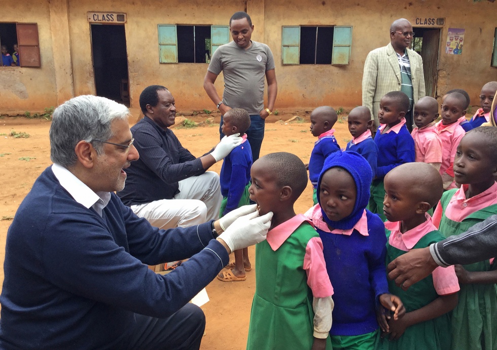 Prof Raman Bedi inspecting a child's mouth